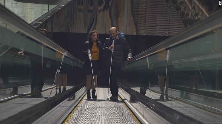 Two people at stairs with WeWALK