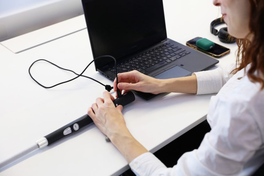A Woman Charging WeWALK In The Office