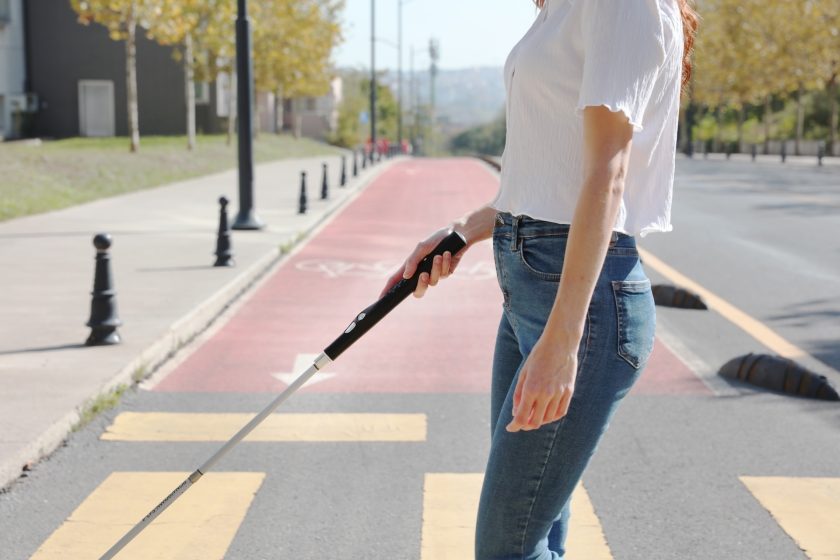A Woman Holding WeWALK On The Street